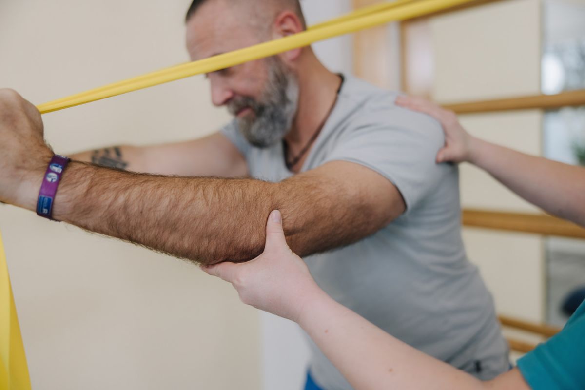 Sportler bei der Durchführung von Reha-Übungen mit elastischen Widerstandsbändern.